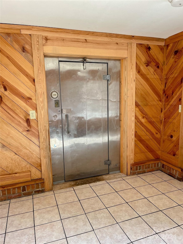 interior space with wooden walls and tile patterned floors