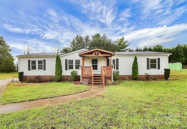 manufactured / mobile home with covered porch and a front yard