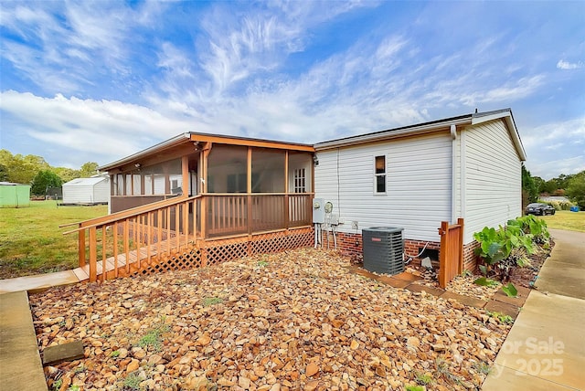 rear view of property featuring a sunroom, cooling unit, and a deck