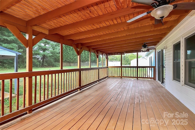 wooden terrace featuring ceiling fan and a lawn