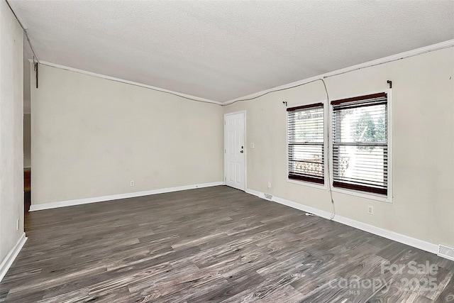 unfurnished room featuring dark hardwood / wood-style flooring, a textured ceiling, and ornamental molding