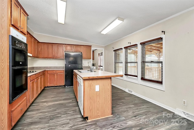 kitchen with a kitchen island with sink, black appliances, sink, vaulted ceiling, and dark hardwood / wood-style flooring