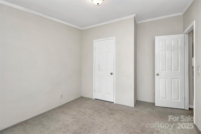 unfurnished bedroom featuring a closet, light carpet, crown molding, and a textured ceiling