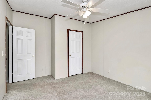 unfurnished bedroom featuring ceiling fan, light colored carpet, and a textured ceiling