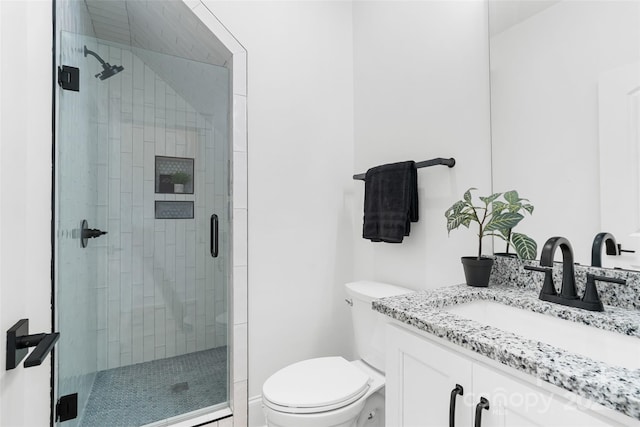 bathroom featuring vanity, toilet, and an enclosed shower