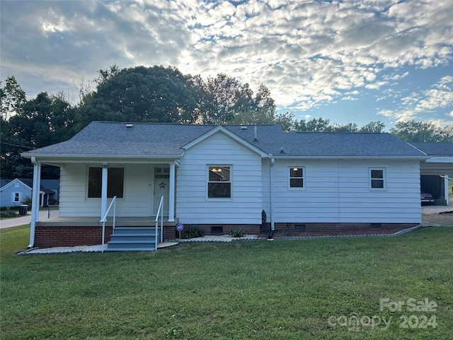 rear view of house with a lawn and covered porch