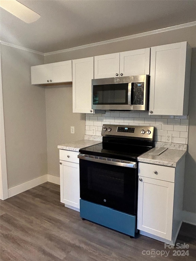 kitchen with white cabinets, appliances with stainless steel finishes, dark hardwood / wood-style flooring, and decorative backsplash