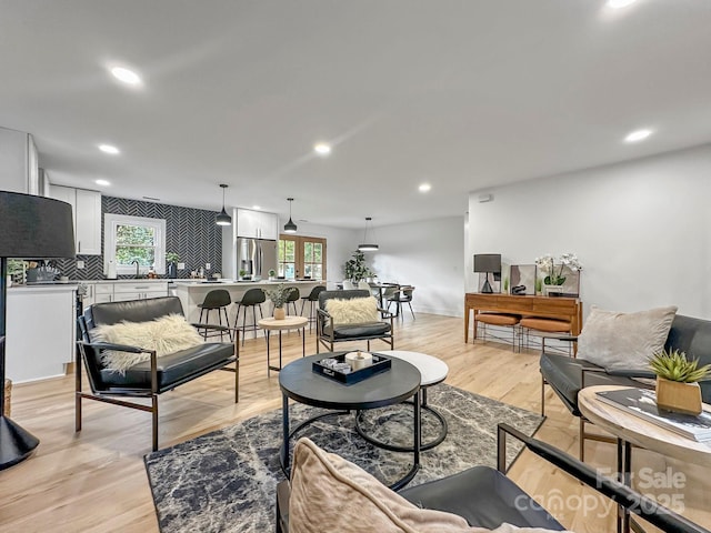 living room with sink and light hardwood / wood-style flooring