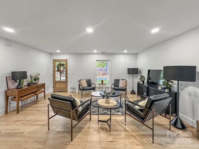 living room featuring a baseboard heating unit and light hardwood / wood-style floors