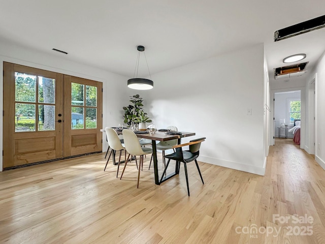 dining area featuring light wood-type flooring and french doors