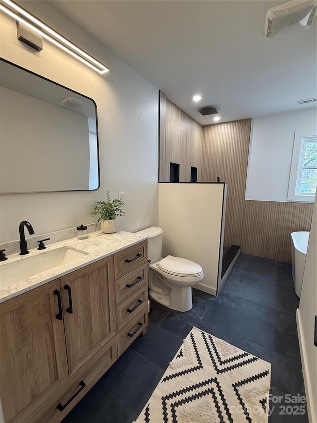 bathroom featuring vanity, toilet, and a shower