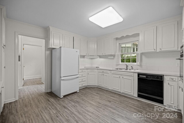 kitchen featuring white cabinets, white refrigerator, ornamental molding, light hardwood / wood-style flooring, and black dishwasher