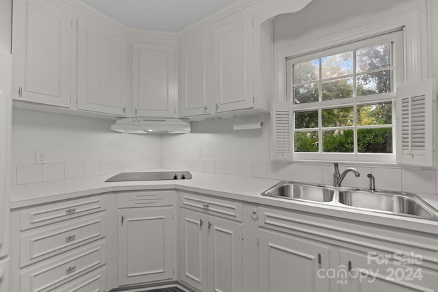 kitchen with black electric cooktop, white cabinets, and sink