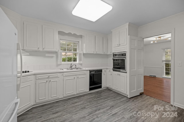 kitchen featuring light wood-type flooring, sink, white cabinetry, black appliances, and ornamental molding