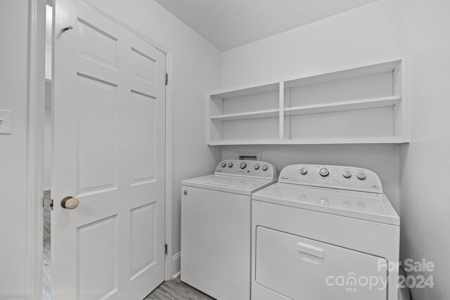 clothes washing area featuring light wood-type flooring and washing machine and dryer