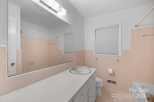 bathroom with vanity, tile walls, toilet, and tile patterned floors