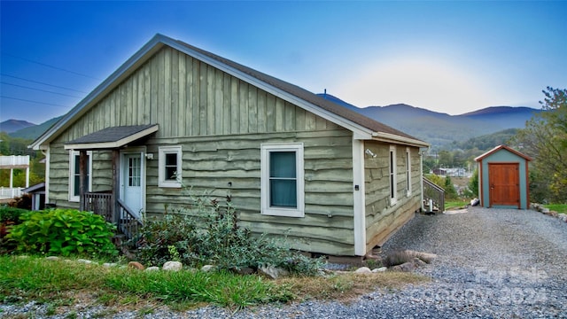 view of property exterior featuring a mountain view and a shed