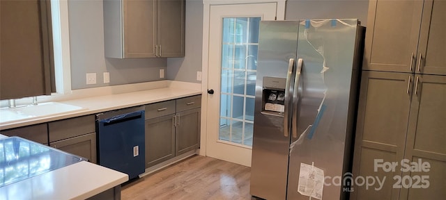 kitchen featuring stainless steel refrigerator with ice dispenser, sink, gray cabinetry, light hardwood / wood-style flooring, and black dishwasher