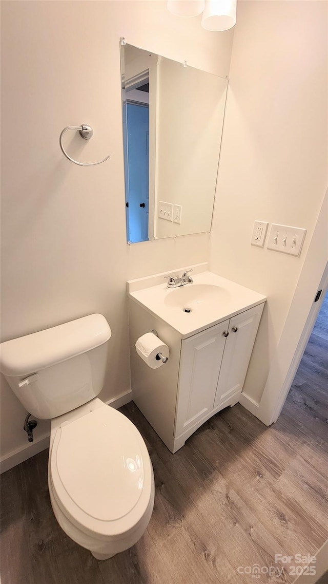 bathroom featuring vanity, hardwood / wood-style flooring, and toilet