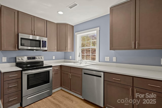 117 Hibriten Mountain Rd SE, Lenoir, NC 28645 - kitchen with a sink, light countertops, light wood-style floors, and stainless steel appliances