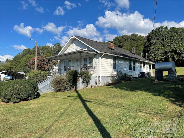 view of side of home featuring a lawn and a porch