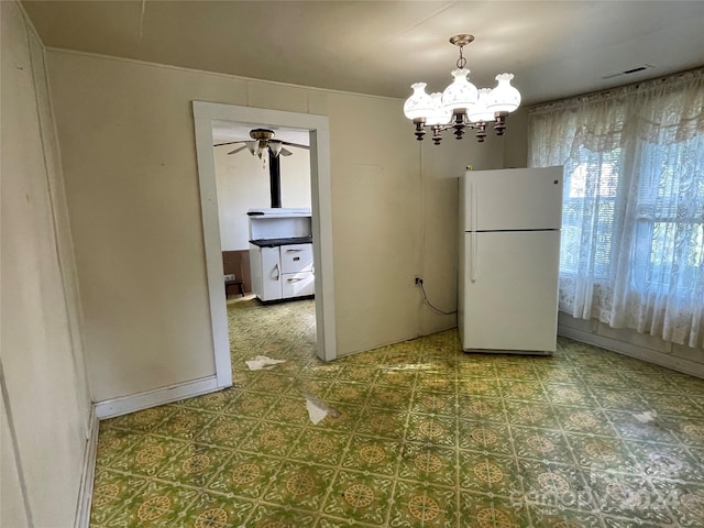 spare room with ceiling fan with notable chandelier