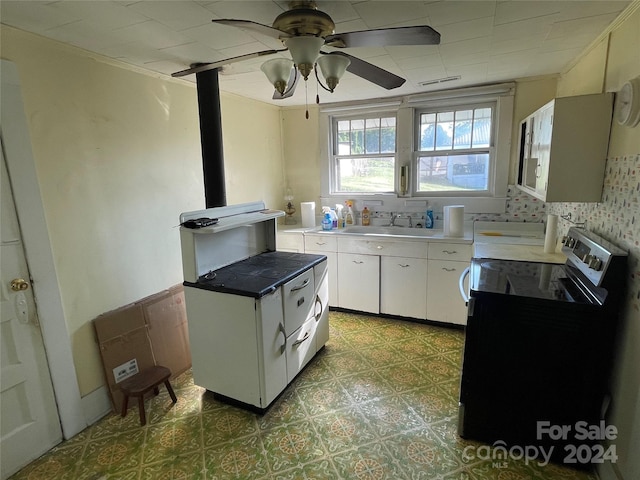 kitchen featuring decorative backsplash, white cabinetry, washer / dryer, ceiling fan, and sink