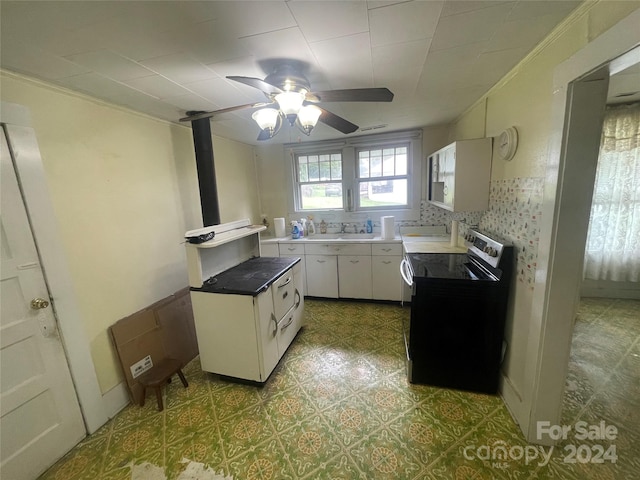 kitchen with white cabinetry, decorative backsplash, ornamental molding, stainless steel electric range, and ceiling fan