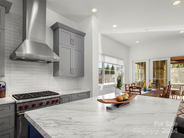 4 Windelsham Way, Arden, NC 28704 - kitchen featuring designer stove, a center island, wall chimney range hood, gray cabinetry, and decorative backsplash