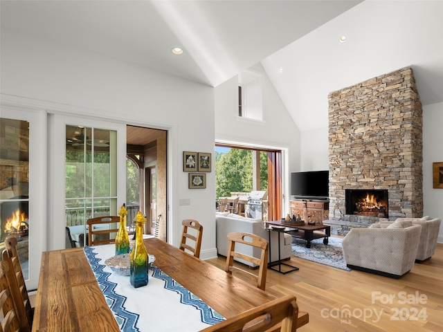 4 Windelsham Way, Arden, NC 28704 - dining area featuring a stone fireplace, high vaulted ceiling, wood-type flooring, and plenty of natural light