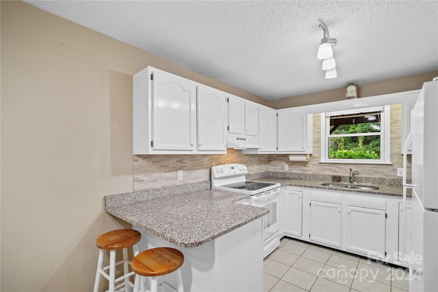 kitchen featuring kitchen peninsula, sink, white appliances, and white cabinetry