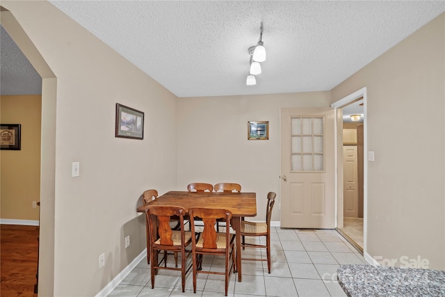 tiled dining area featuring a textured ceiling