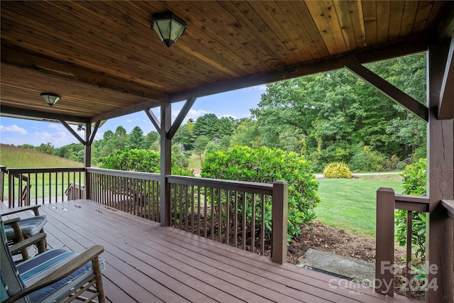 wooden deck featuring a lawn