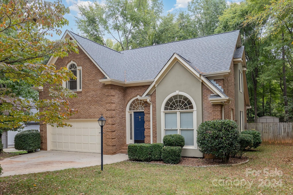 view of front of home with a garage and a front lawn