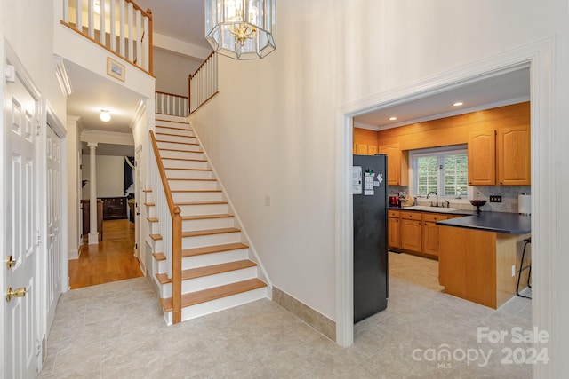 interior space featuring ornamental molding, sink, tile patterned flooring, and a chandelier