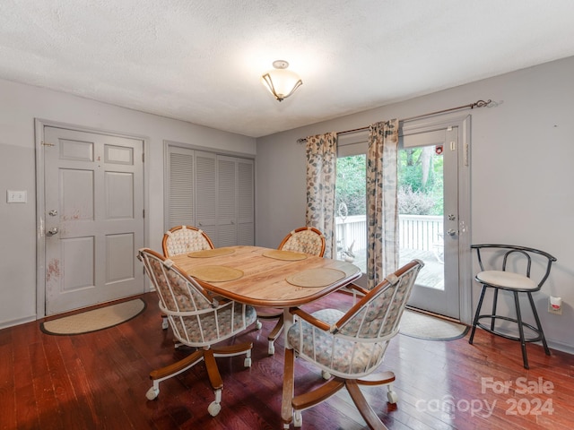 dining space with a textured ceiling and wood-type flooring