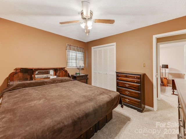 carpeted bedroom with ceiling fan and a closet