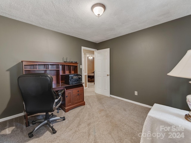 office area with a textured ceiling and light colored carpet