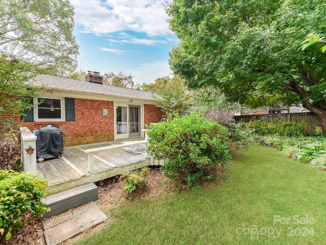 exterior space with a deck and a lawn