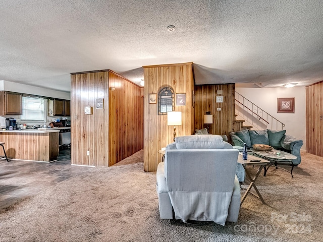 carpeted living room featuring a textured ceiling and wooden walls