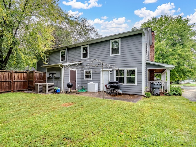 rear view of property with a yard and central AC unit