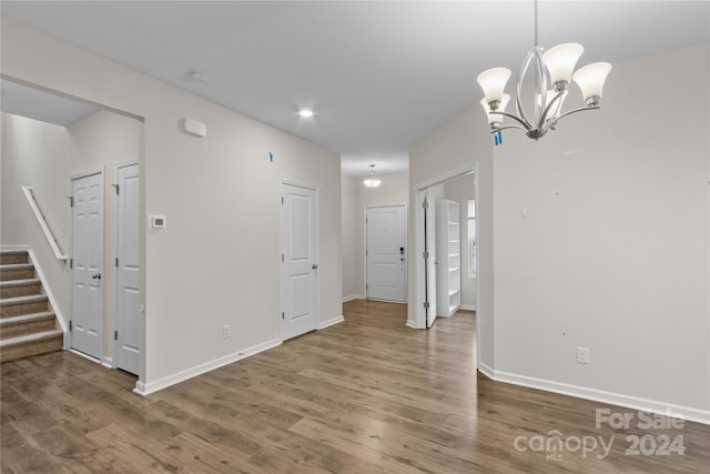 empty room featuring a notable chandelier and hardwood / wood-style flooring