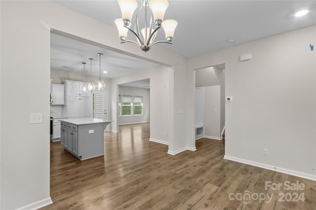 kitchen with hanging light fixtures, a chandelier, dark hardwood / wood-style flooring, and a kitchen island