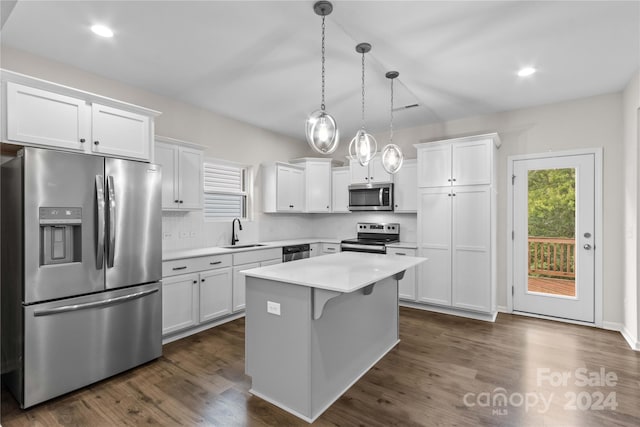 kitchen featuring sink, white cabinetry, a kitchen island, appliances with stainless steel finishes, and decorative light fixtures