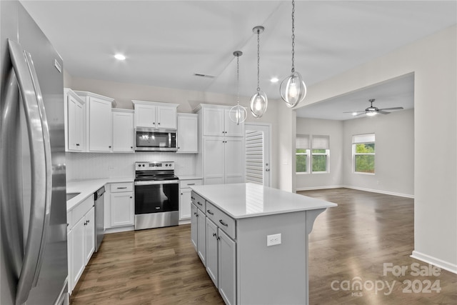 kitchen with a center island, dark wood-type flooring, white cabinets, stainless steel appliances, and ceiling fan