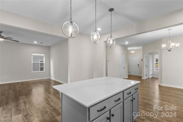 kitchen featuring ceiling fan, decorative light fixtures, dark hardwood / wood-style flooring, and a center island