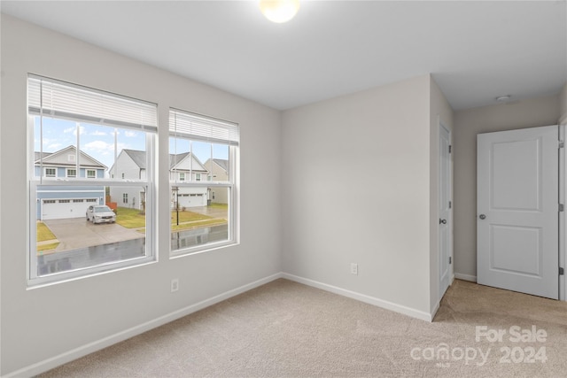 spare room featuring light colored carpet