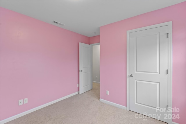 unfurnished bedroom featuring light carpet