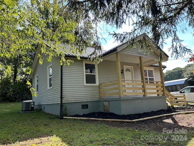 view of front of property with a front lawn, central AC, and a porch