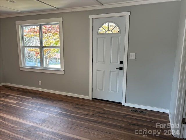 foyer with ornamental molding and dark hardwood / wood-style floors